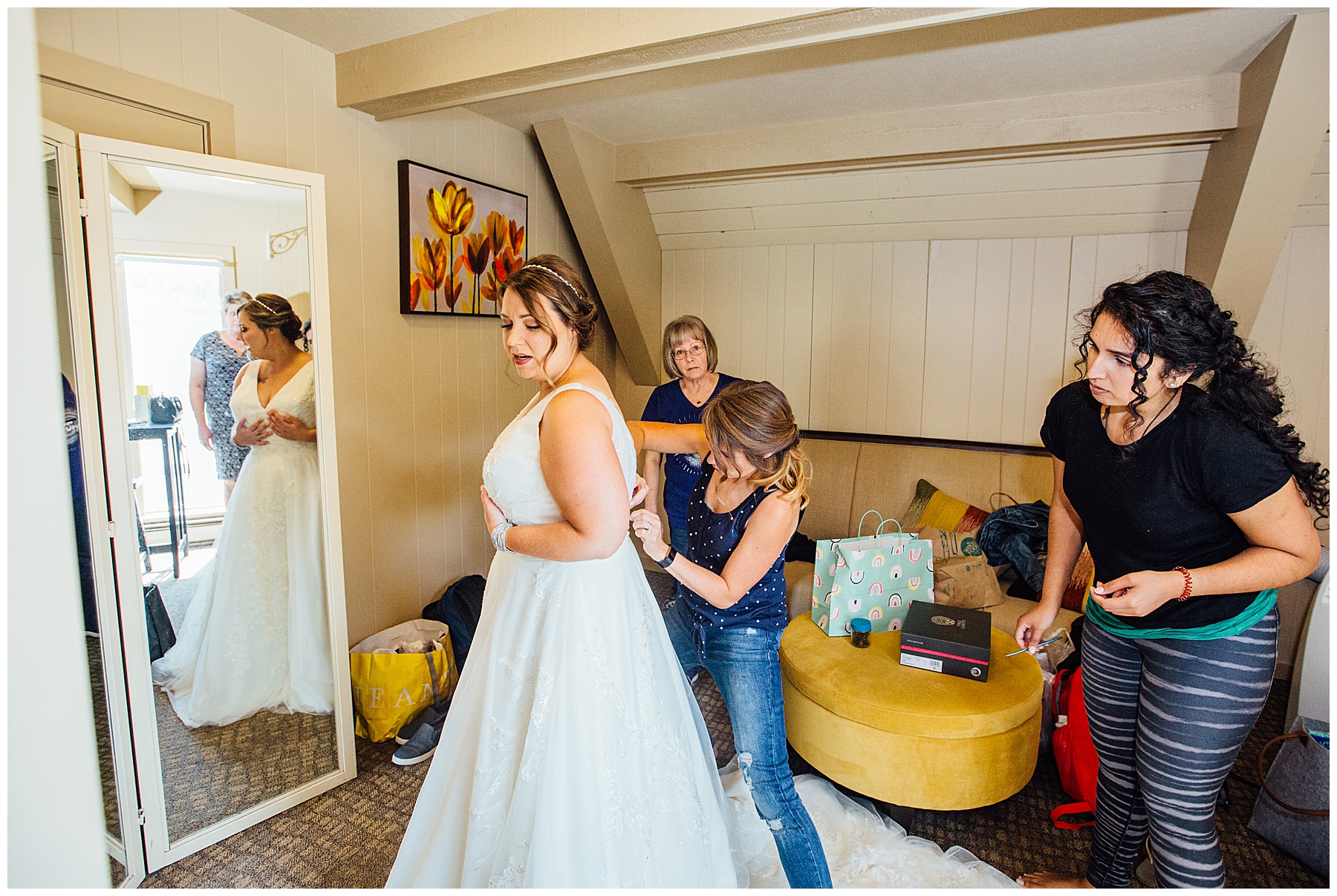 Friends of Bride helping her put on dress