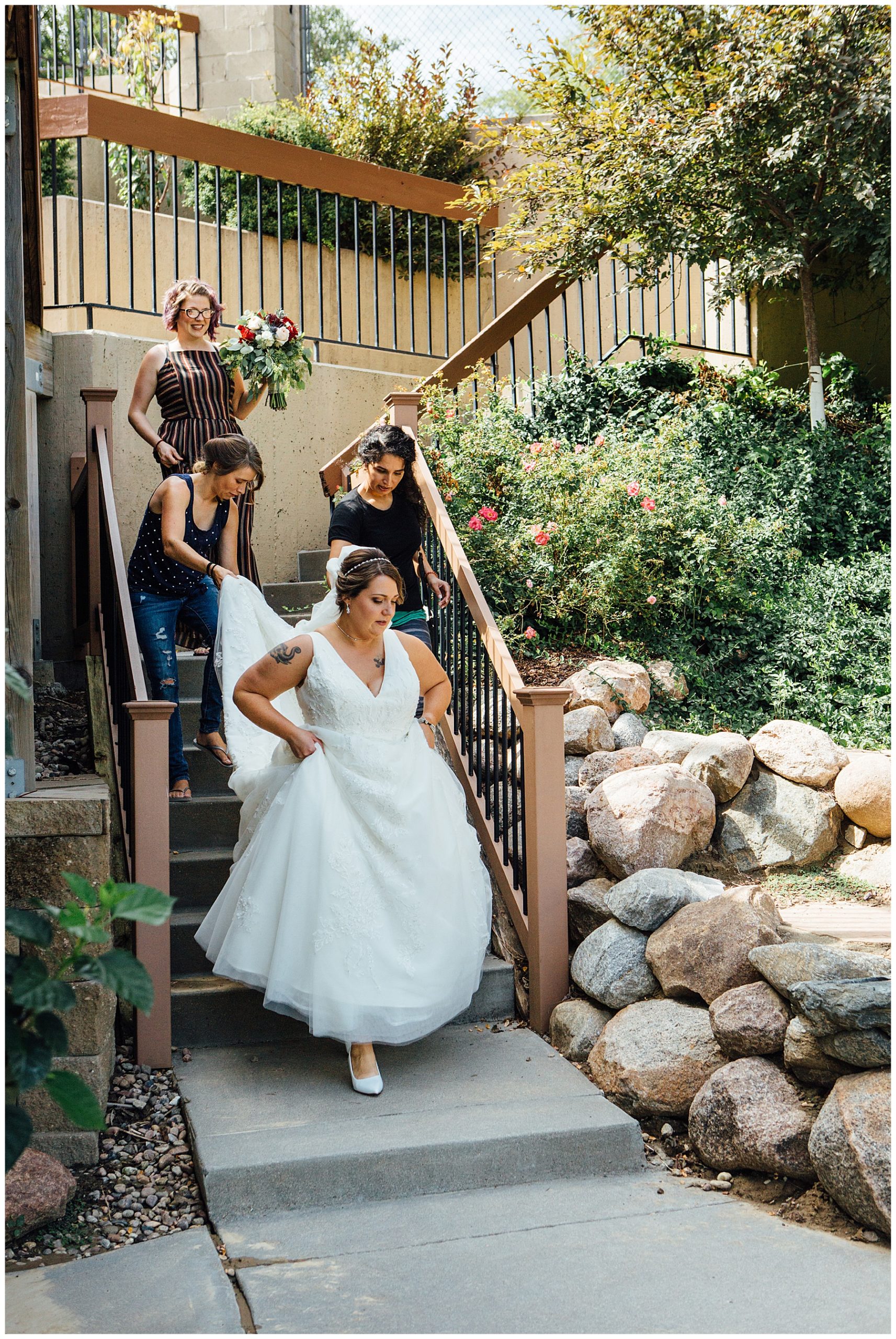 Friends of Bride helping her walk down stairs