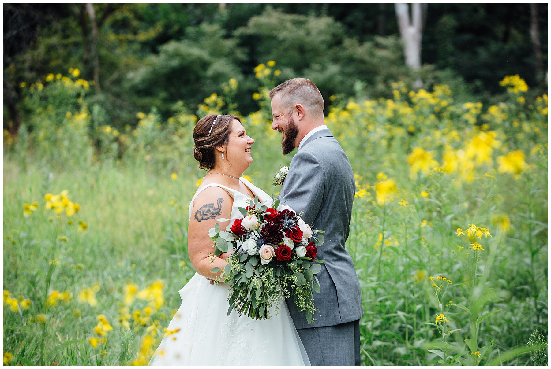 Bride and groom looking at each other in a field