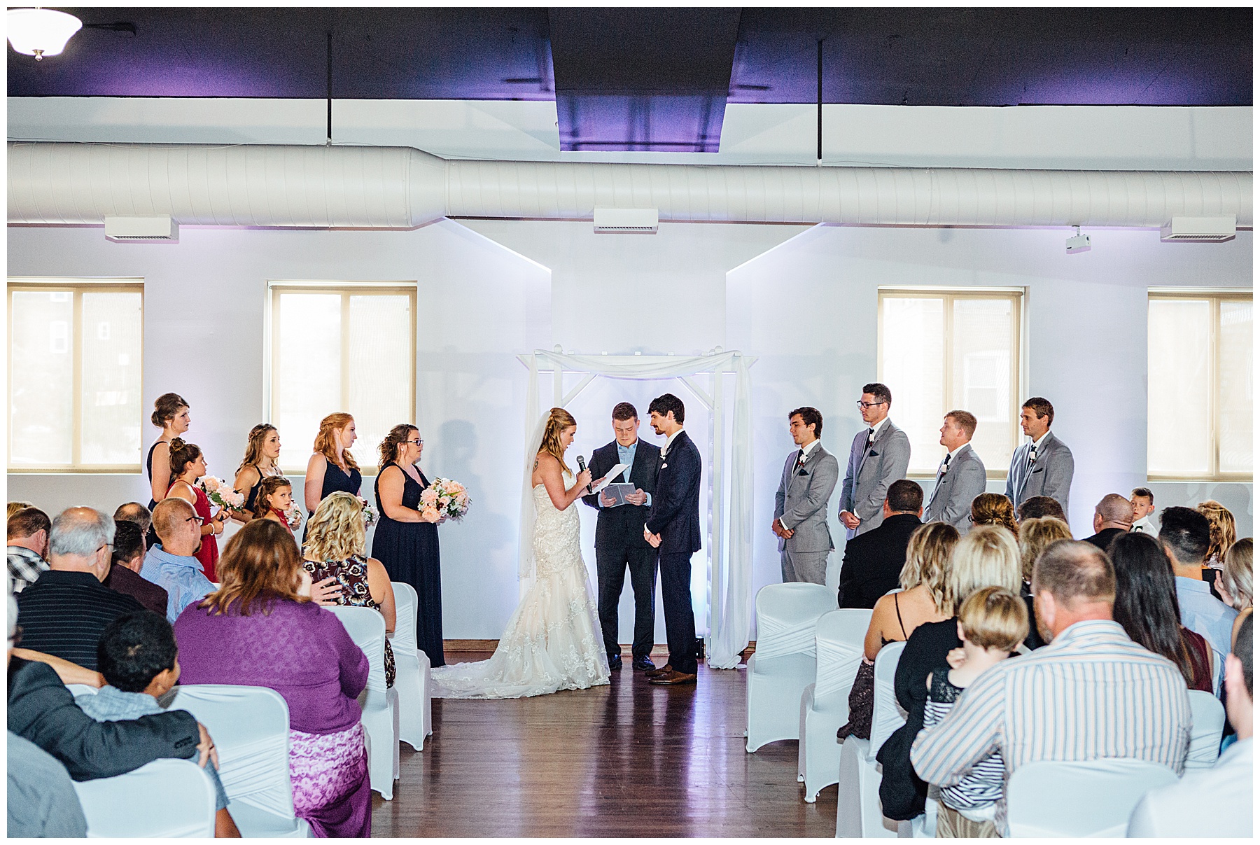 Bride and groom putting on rings at Simply Ballroom wedding photos