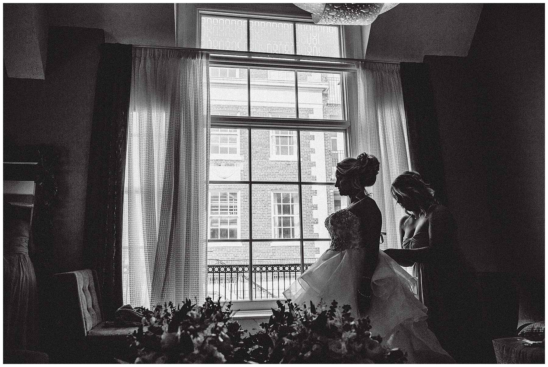 Black and White of Bride putting on dress