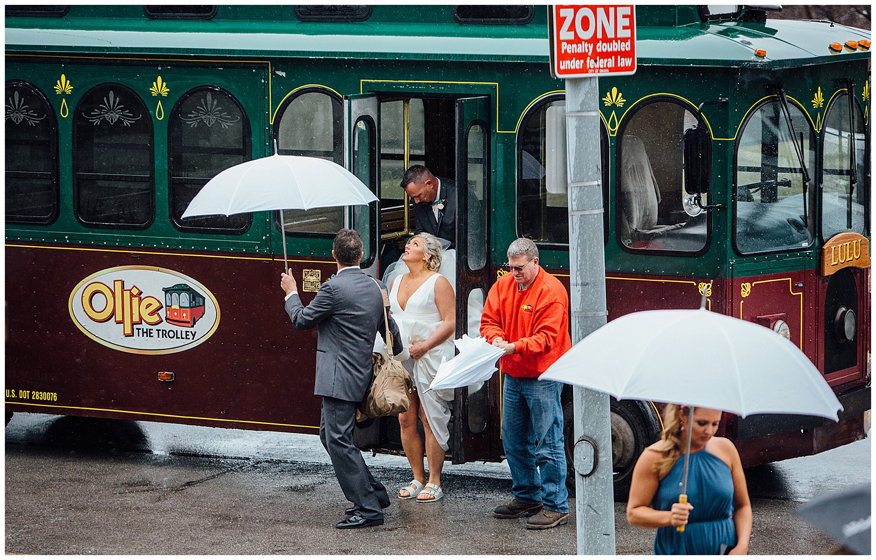 Bride holding dress in rain