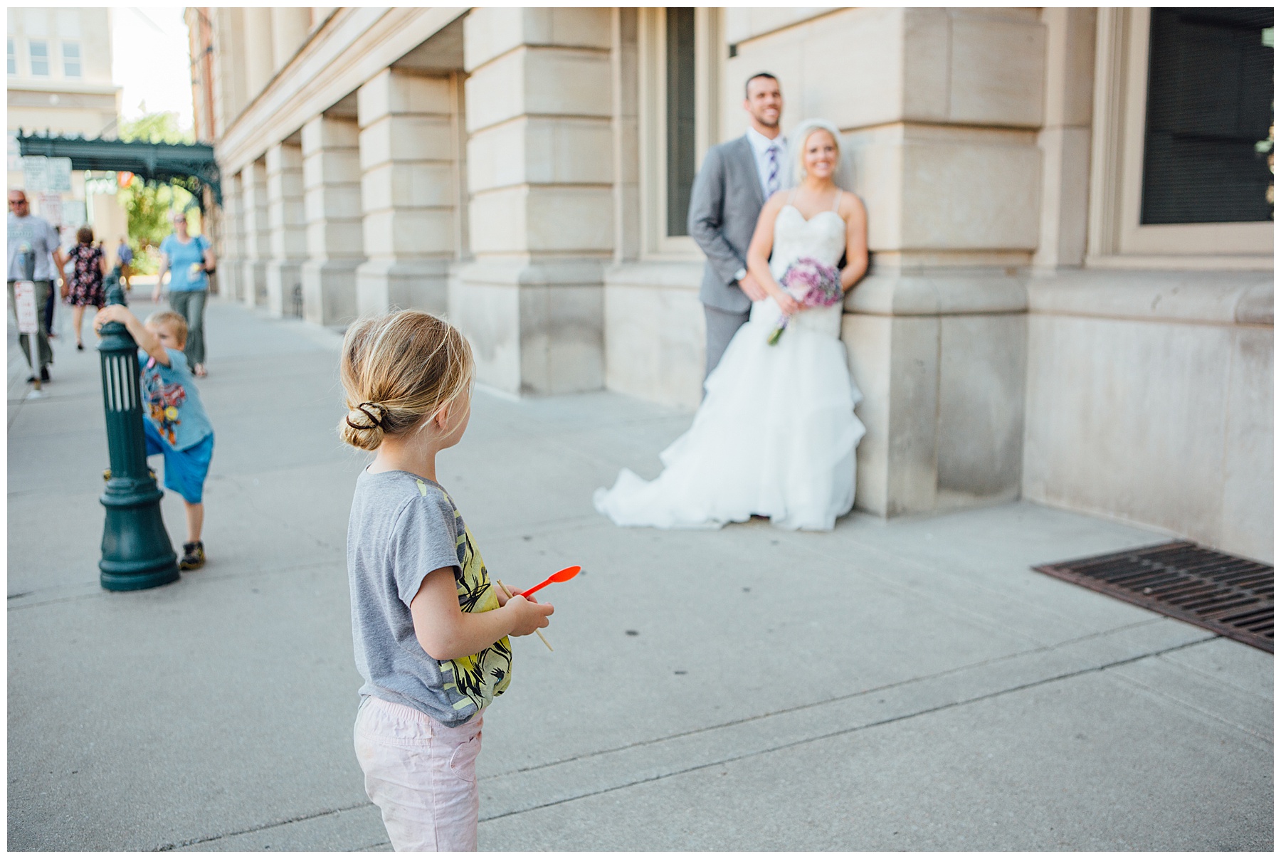 little girl looking at bride and groom