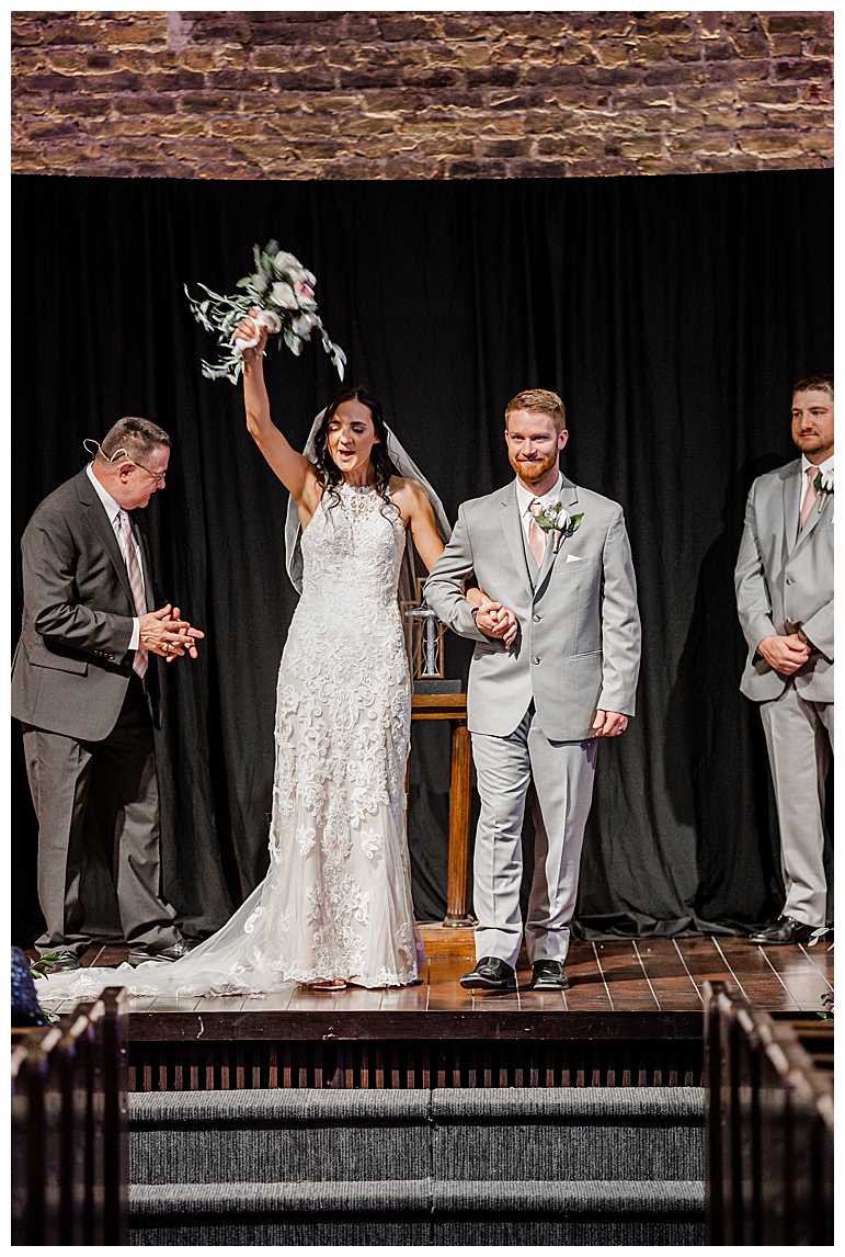 Bride raising bouque in air